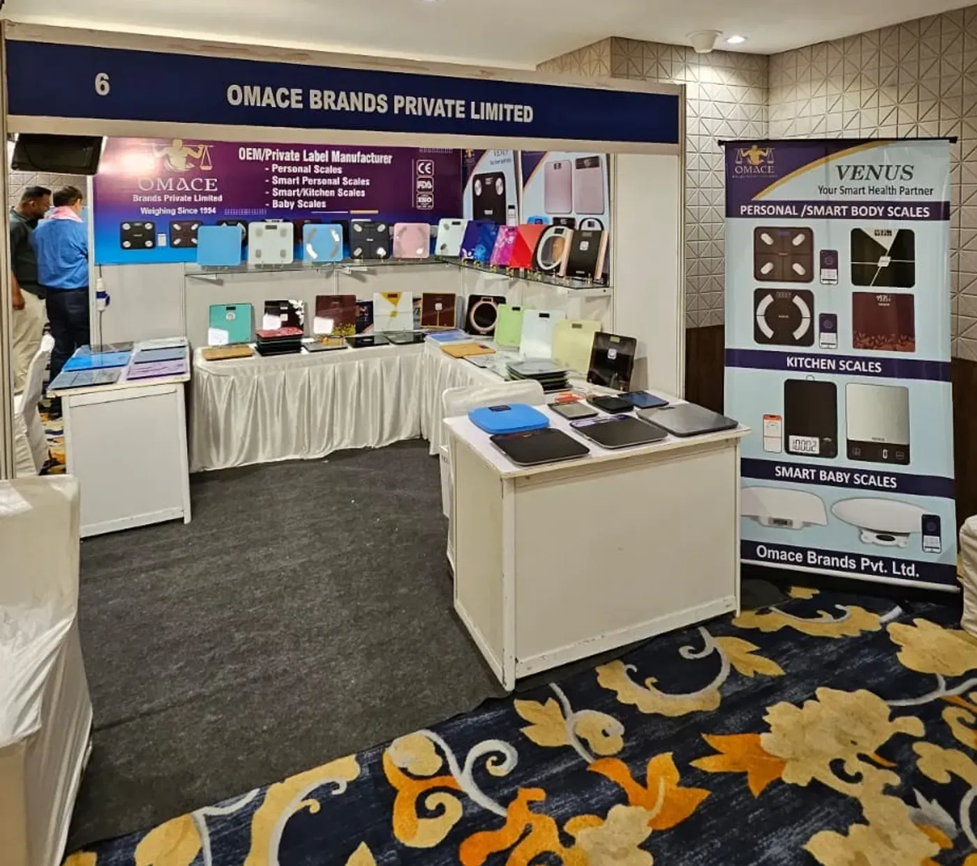 Omace Brands stall 6 at the AIFWITA National Convention in Jaipur, August 2026, with Venus and Hoffen scales on display
