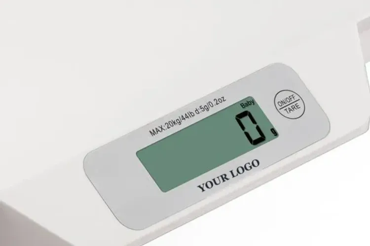 Close-up of a baby scale display panel with YOUR LOGO printed under the backlit LCD