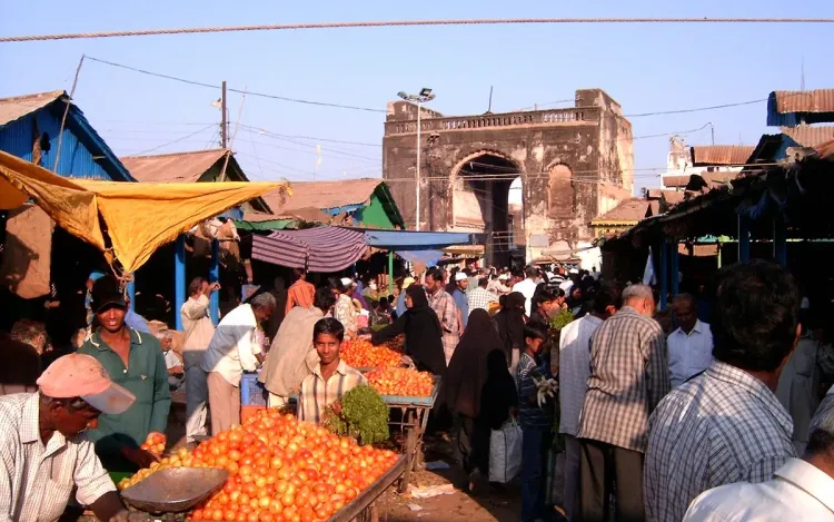 Busy produce market in Hyderabad, India, with a vendor weighing tomatoes, for poultry, meat and agri businesses