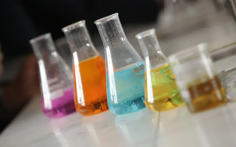 Coloured liquids in glass flasks on a laboratory bench, for lab and pharma equipment suppliers